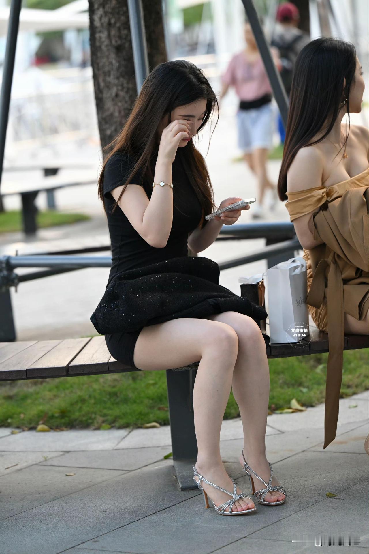 街头认真看手机的模特小姐姐，包臀裙搭配亮银色高跟凉鞋，美的如此出彩！