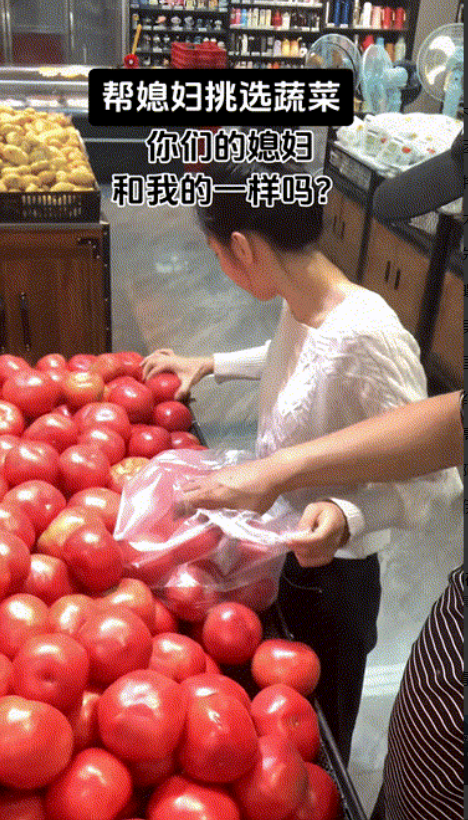 一名女子非常认真地在超市里挑选西红柿，她的丈夫从她挑出来的袋中拿出一个，假装是