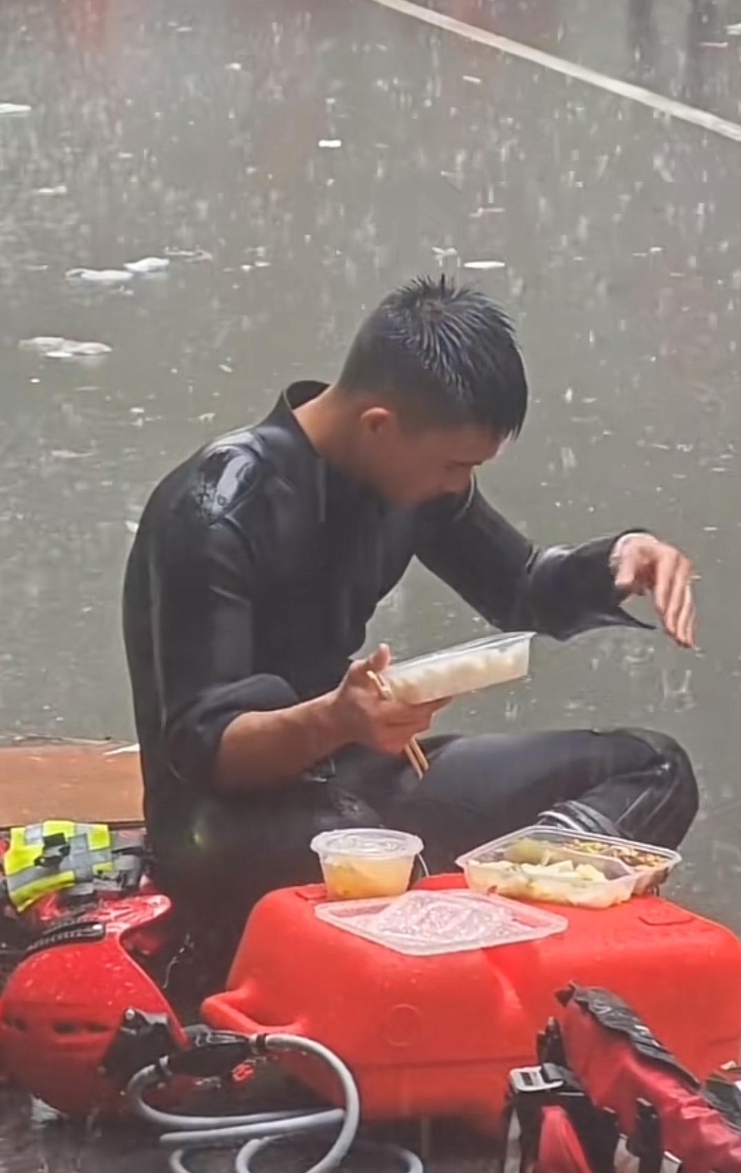 这就是我们的人民子弟兵，在救灾现场席地而坐，在雨中用餐，全身被雨水浸透，饭盒中灌