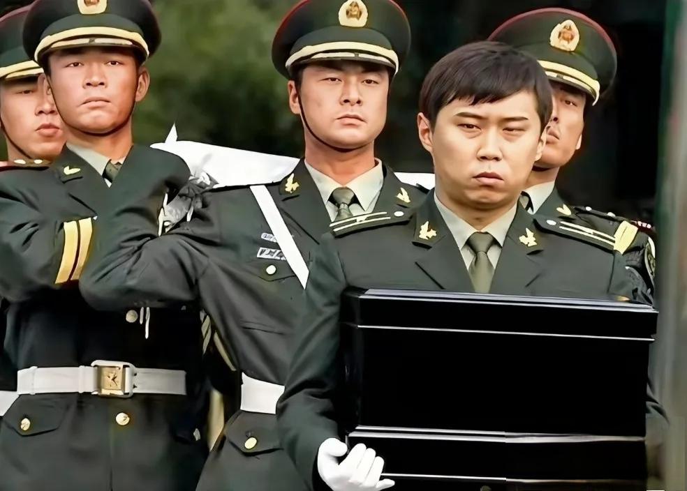 2009年11月，钱学森告别仪式上，孙儿钱磊手捧祖父的骨灰盒，走在队伍前面，满脸