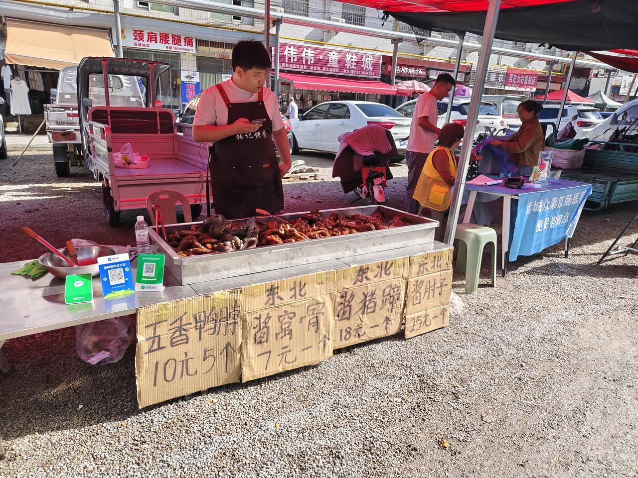 瞧瞧，在运城盐湖西街早市，一小伙子在卖各种卤味，鸭脖10元5个，东北酱窝骨7元一