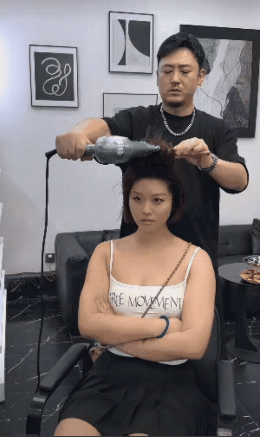 笑不活！理发店内的尴尬一幕.理发店内，一位帅气的理发师，在专心致志给女子做发