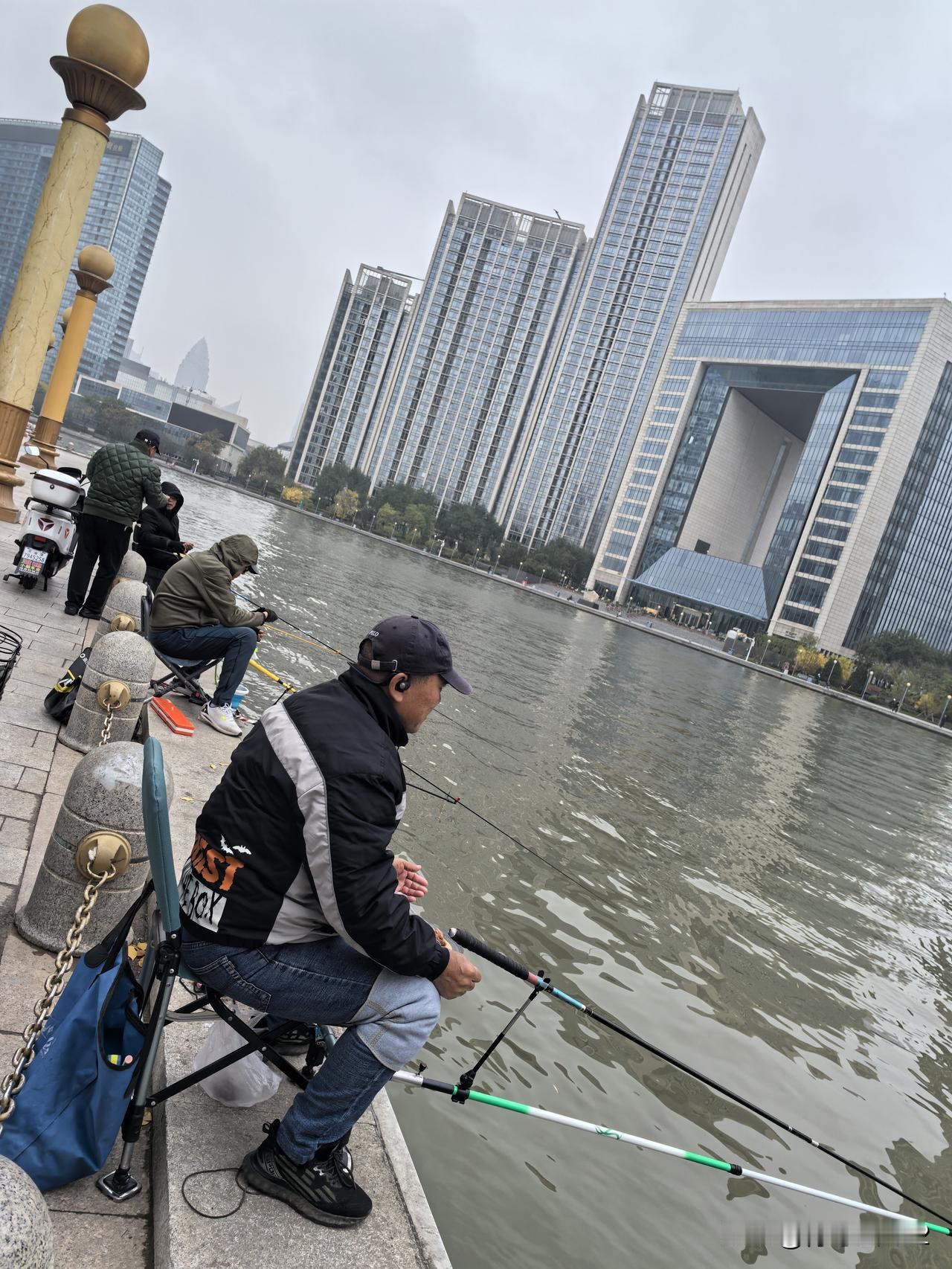 天津海河边的钓鱼爱好者还真不少呢！这是我在海河边散步时拍到的。这些钓鱼爱好者迎