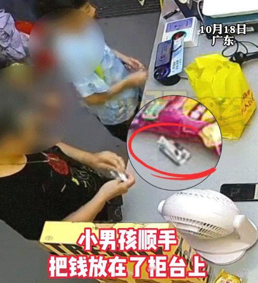 广东一超市内，一名小男孩与一位大妈同时在柜台结账。男孩将钱放在柜台上，转身去捡东