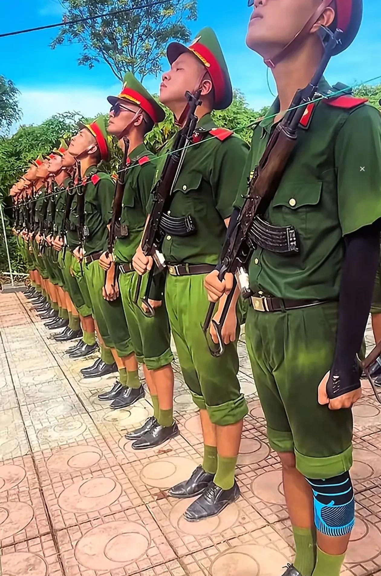 照片上的越南仪仗队军人在夏天的炎炎烈日之下苦练分列式动作，汗水已经完全浸湿了他们