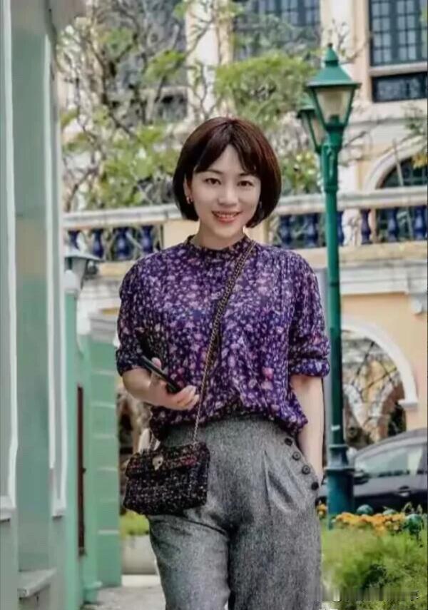 这是一位比董卿有气质的才女，她打扮干练，穿搭简约，背一个小包包，拿着小手机，气质