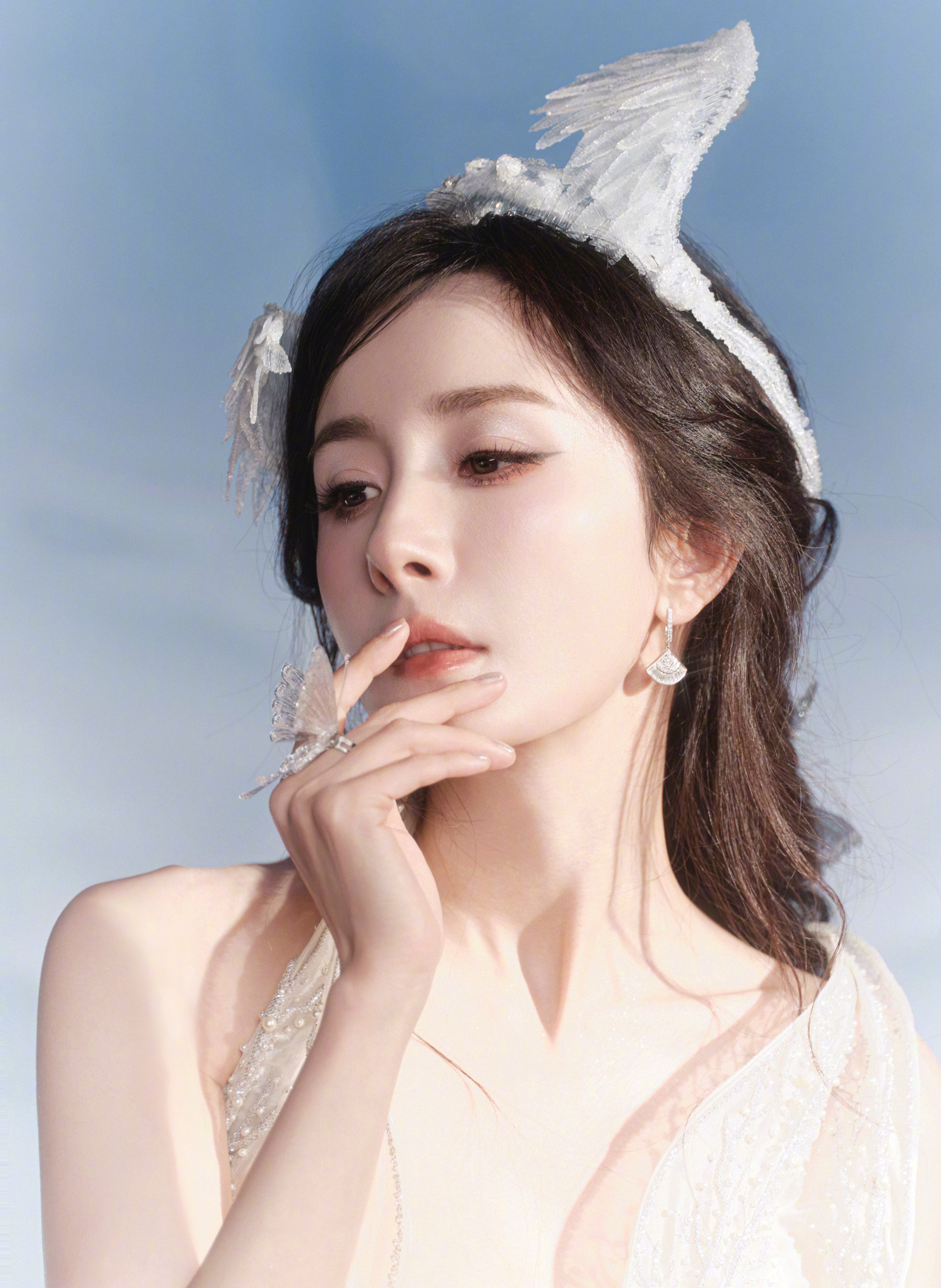 杨幂携霜棱为弓，白裙缀满星子似的碎光，在冷雾氤氲处，活成了凛冬里最锋利的那束光。