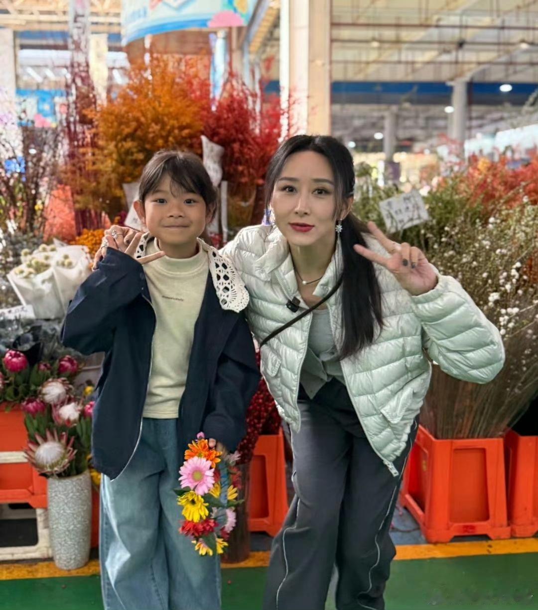 48岁胡静在昆明菜市场被偶遇，她化着大红唇，妆容精致，一头长发乌黑发亮，外表看起