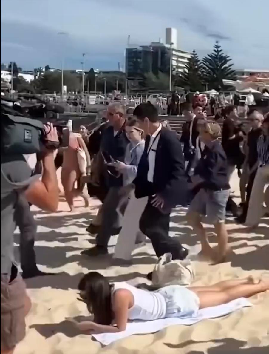 哈里梅根带着安保团队和媒体大阵仗现身邦迪海滩，摄影师、保镖、随行人员乌泱泱一片。