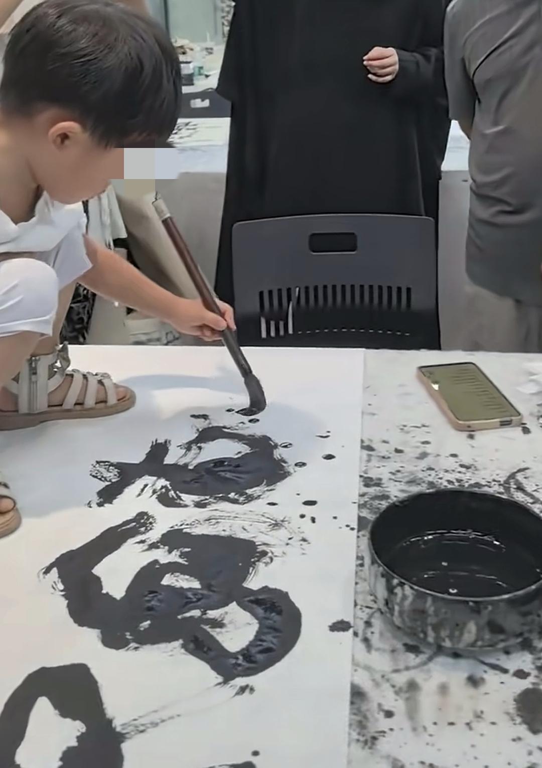 这会成为书法的流行款式吗？刚才看到这个视频，一个小娃站在桌子上写字，被周围的人啧