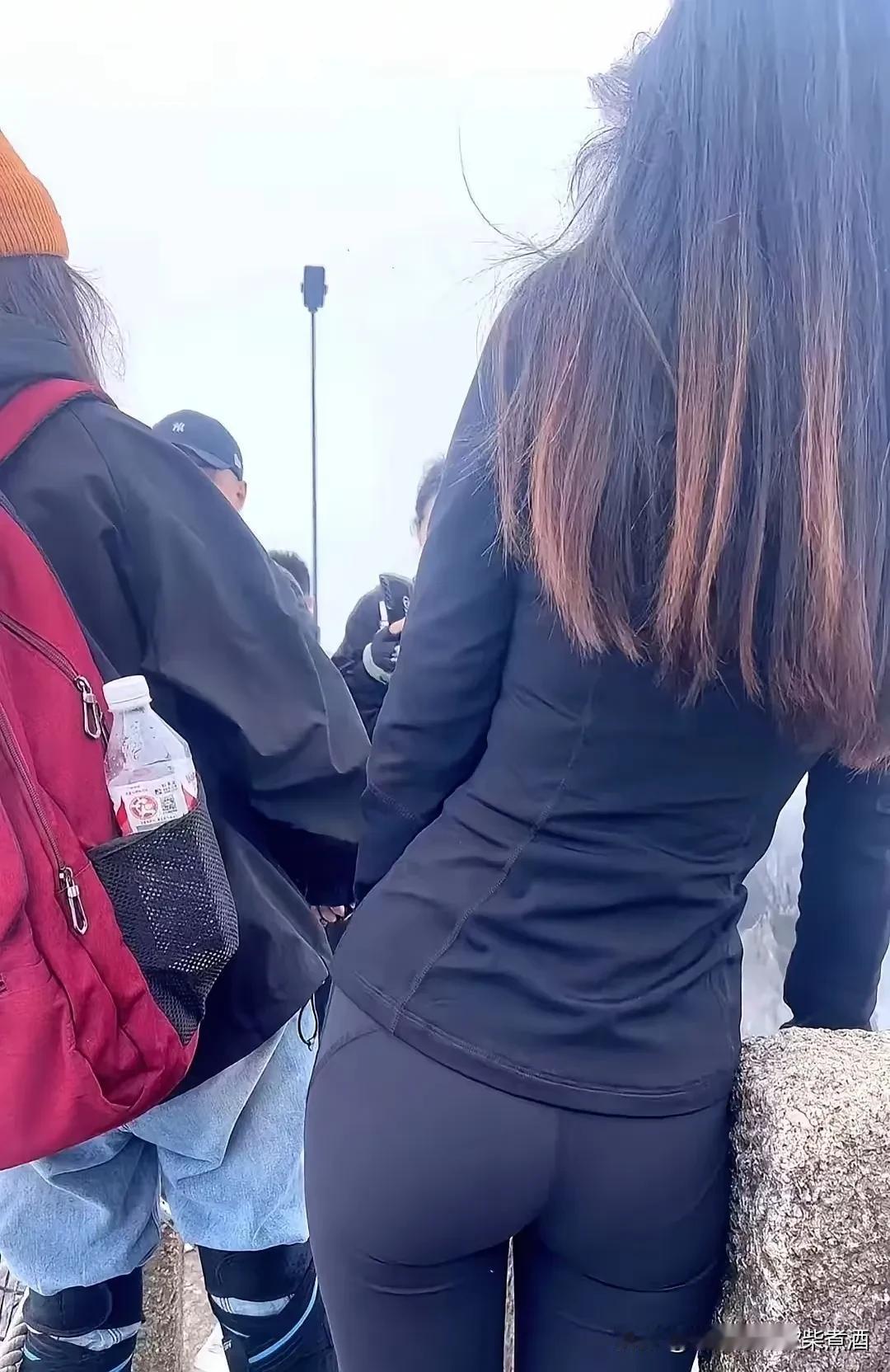 黑色运动背心+蜜桃色紧身裤，腰线完美，姿势优雅，——只是，这真的适合户外拓展吗？