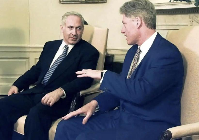 克林顿面前的内塔尼亚胡。克林顿的左手掌心向下，不知在给内塔尼亚胡讲解什么，内塔