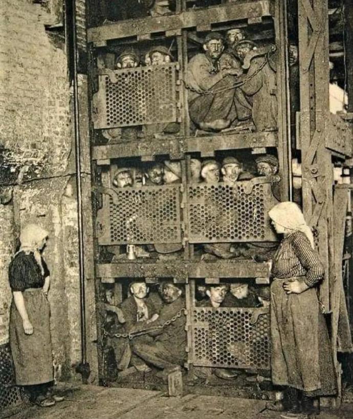 1900年，比利时煤矿工人在长时间的劳动后，挤在电梯里准备下班​​​