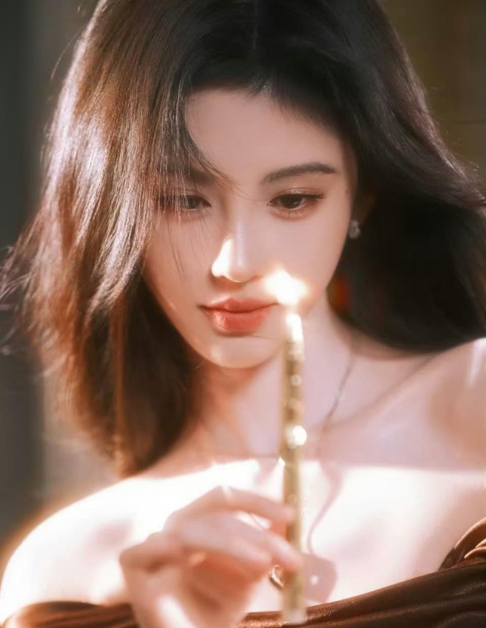 鞠婧祎身穿深棕色缎面一字肩长裙，裸肩剪裁凸显肩颈线条，垂坠感面料勾勒窈窕身型，鎏