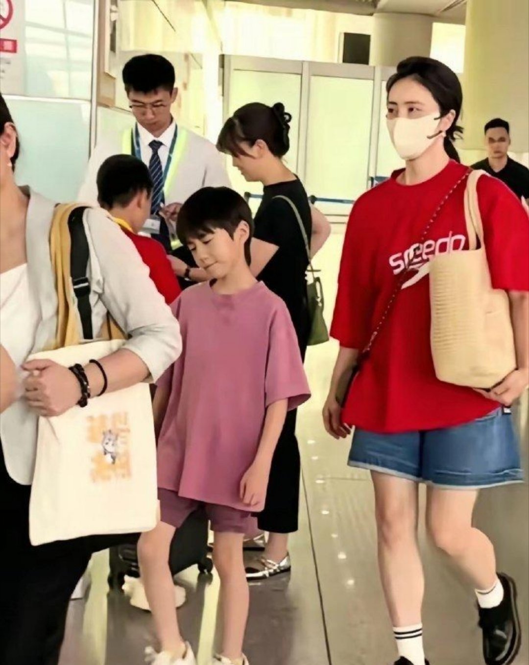 孙莉49岁带3个孩子现身机场，街头风穿搭年轻减龄，和2个女儿像姐妹，二女儿长大了
