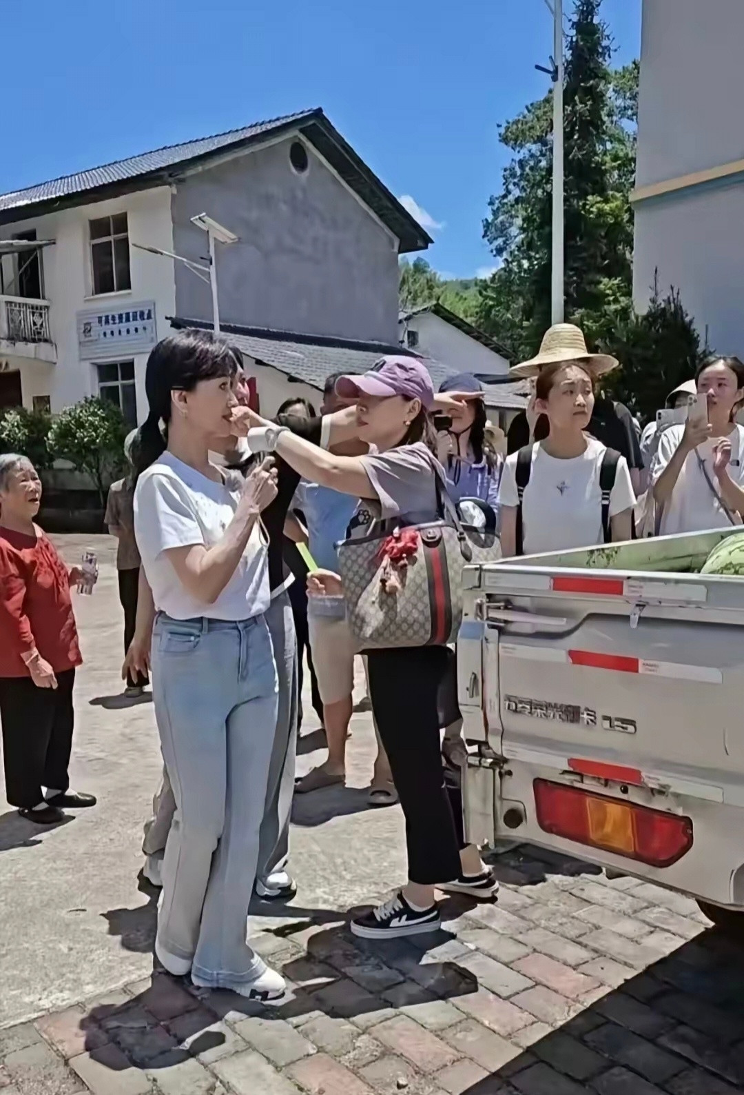 73岁的赵雅芝在烈日下和小朋友们打乒乓球，穿着白色T恤牛仔裤的她，身材纤瘦、体态