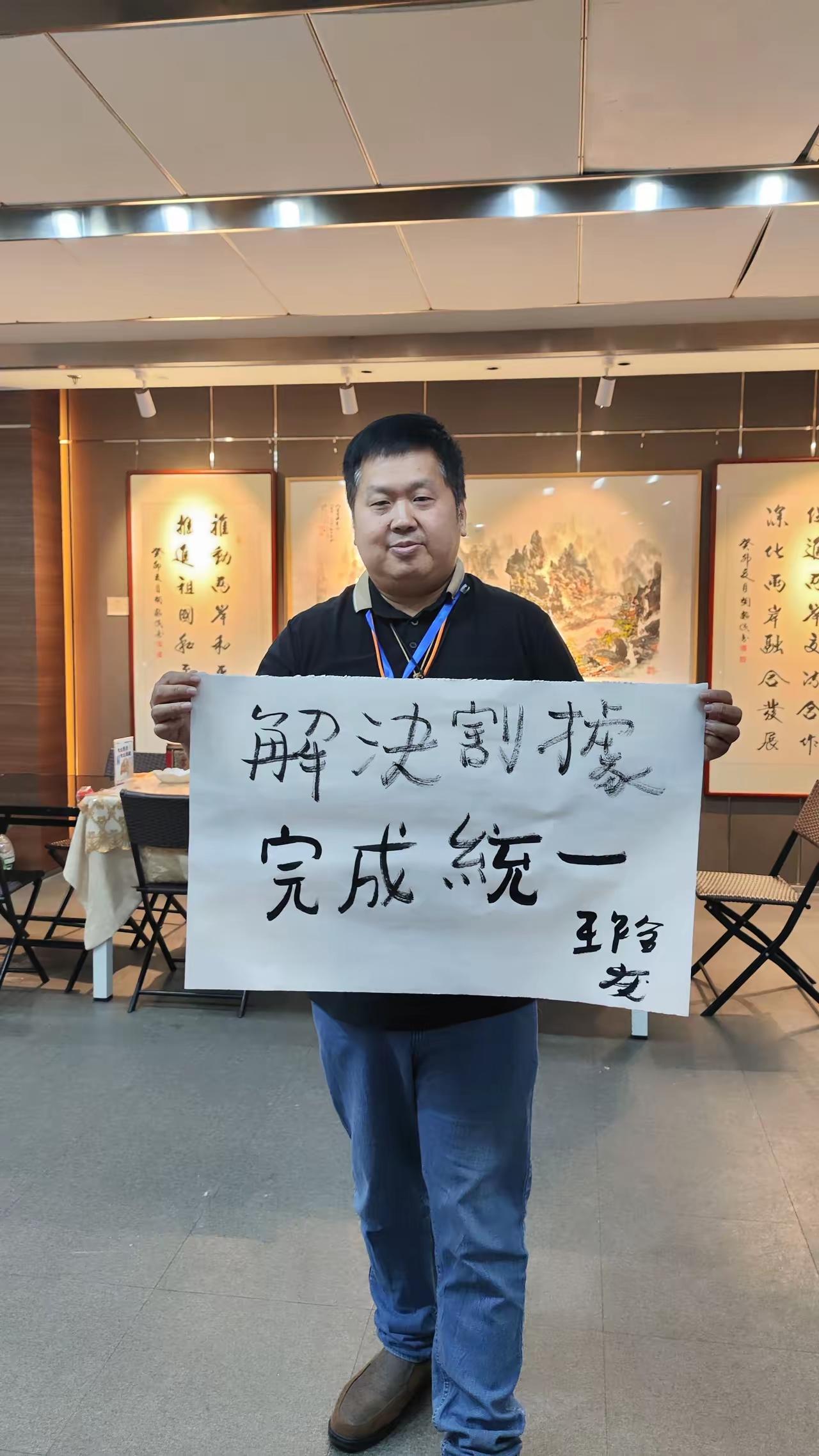 解决割据，完成统一！台胞一纸书法，道出亿万国人共同心声画面当中，王先生手持