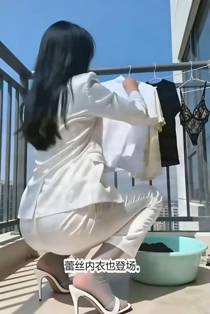 蹲阳台晾衣忙，高跟套裙配白袜。盆里衣物一件件，挂上横杆迎风扬。白T黄衫依次排，蕾