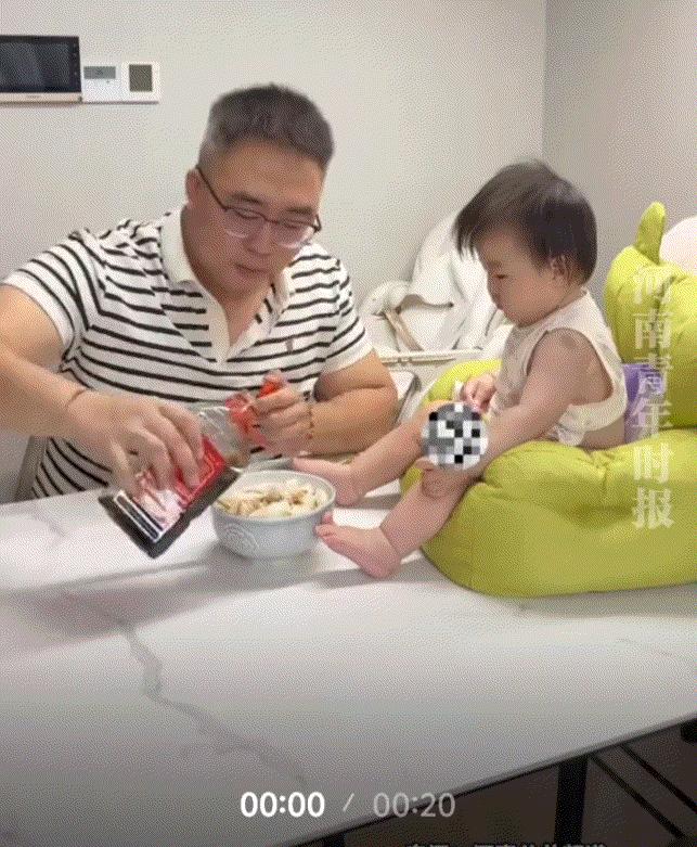 笑不活了！浙江，一爸爸下了一碗面条吃，这宝宝则坐在爸爸面条碗不远处独自玩耍，而爸