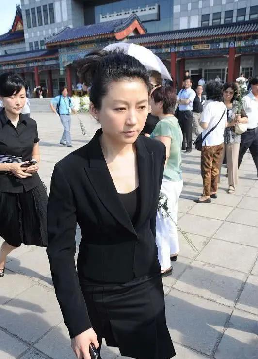 50多岁的年龄了，出现在大街上，一点也不显老。照片中的她，一头乌黑的长发，盘成了