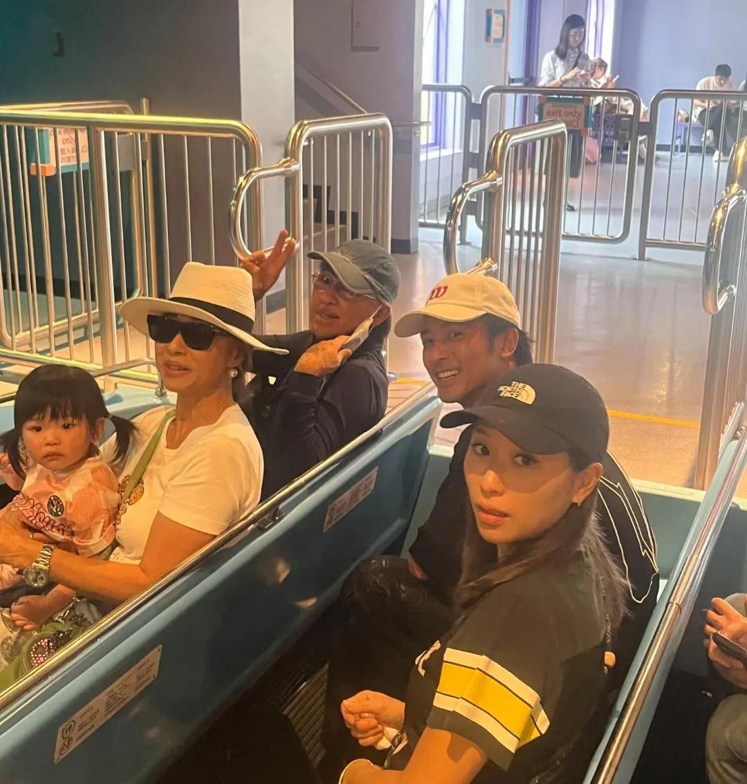 林子祥和老婆叶蒨文现身香港迪士尼乐园，一家人坐在过山车上面非常开心，叶蒨文抱着孙