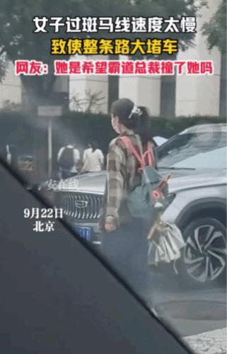 你永远猜不到什么原因导致的堵车。近日，在北京繁华的金融大街，一女子以极慢的速度