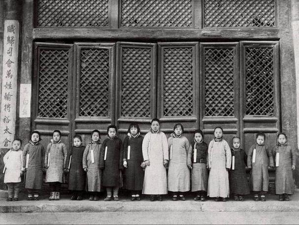 这是张清末内务府上三旗包衣选秀的照片，画面中十二名梳着齐眉短发的少女，身着深色斜