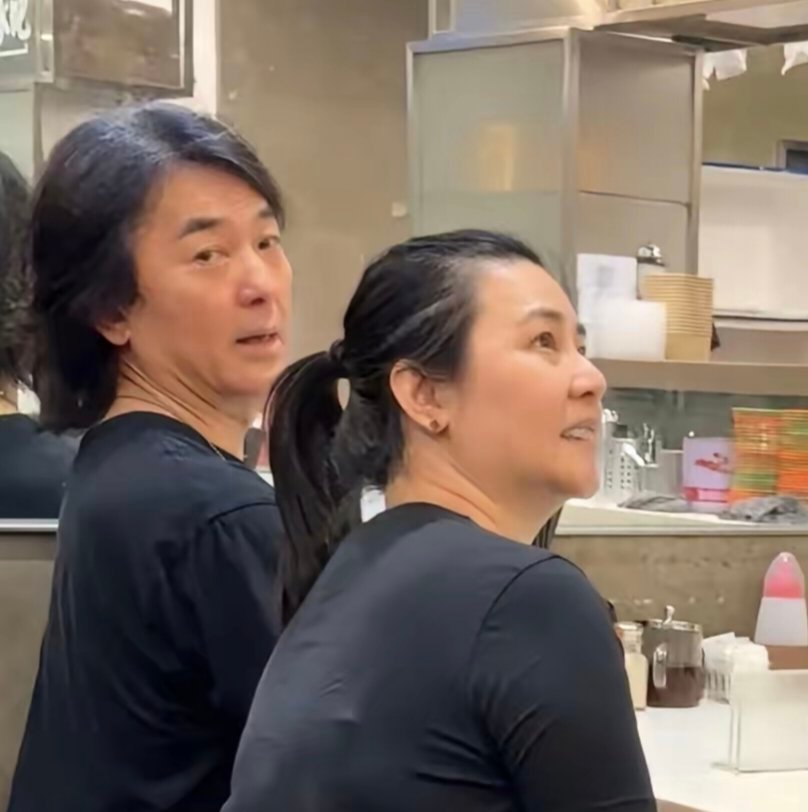 郑伊健与老婆蒙嘉慧坐在香港街头一家面馆吃拉面，夫妻俩穿着简单朴素非常接地气​​