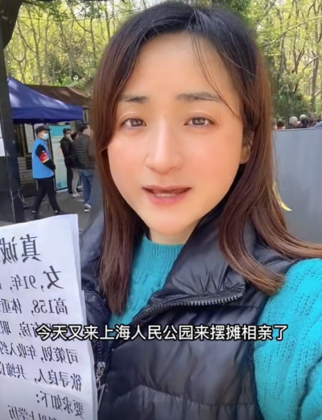 80万彩礼，少一分免谈！”浙江相亲角，38岁硕士女李梅举牌瞬间引爆全场。她一身白