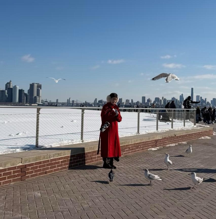 28岁徐娇在美国旅游被偶遇，她穿着红色大衣和长筒皮靴，化着精致的妆容，看起来很贵