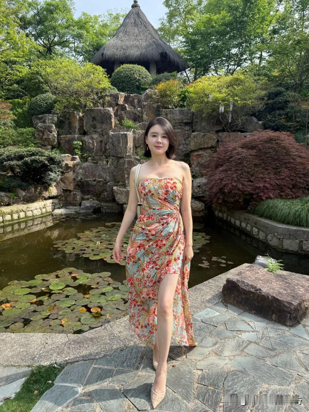 碎花裙裁进园林的夏，荷叶与石瀑作陪，每一步都踩着诗意的涟漪～草亭垂着光阴的影