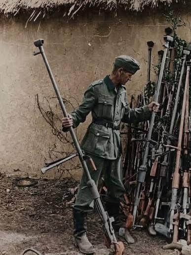 这张照片显示，1943年，一名德国士兵在东线战场上检查缴获的一批苏联PTRD