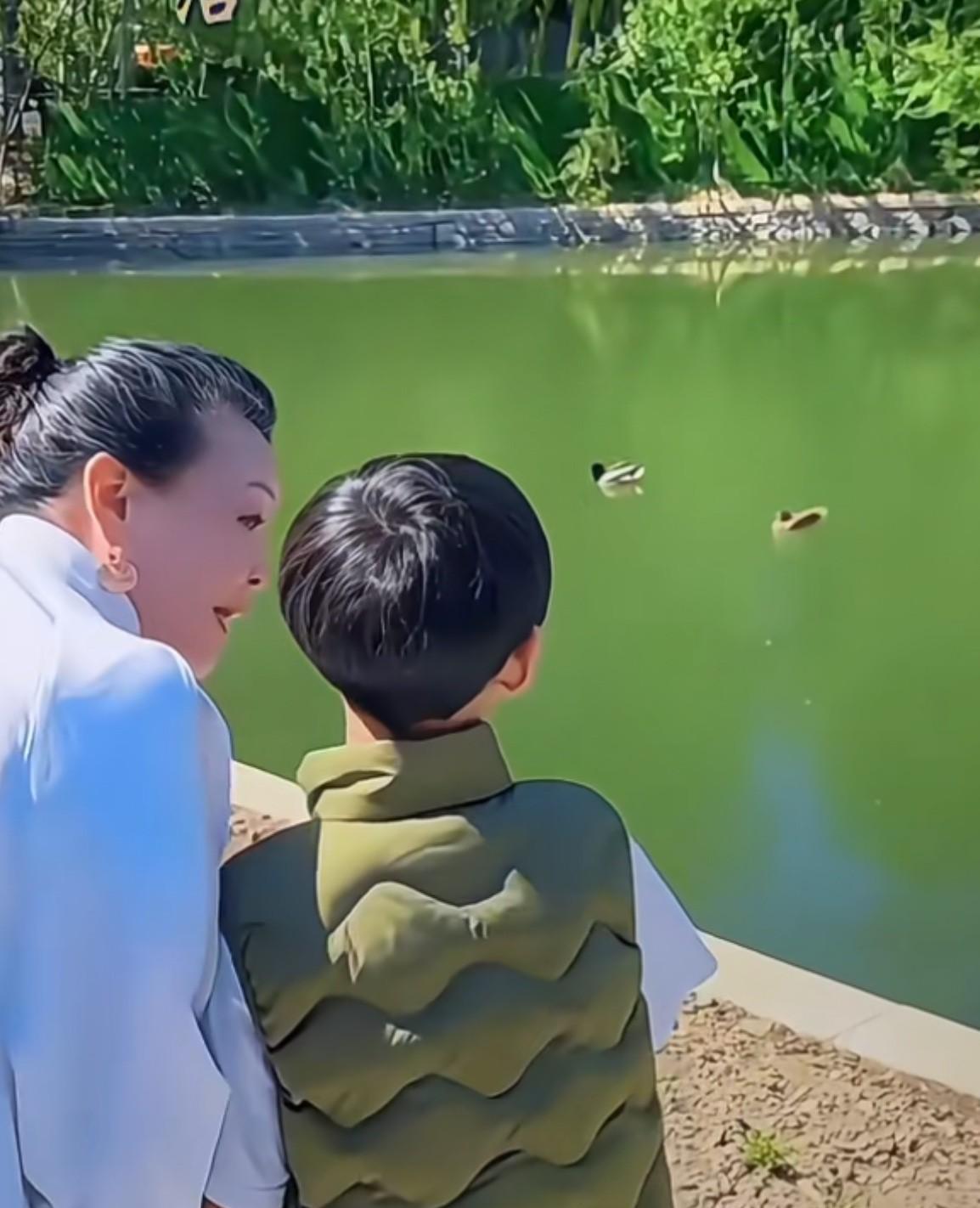 这画面也太温馨了吧！张兰终于心愿达成！牵着孙子的手漫步在北京的公园里！一身白