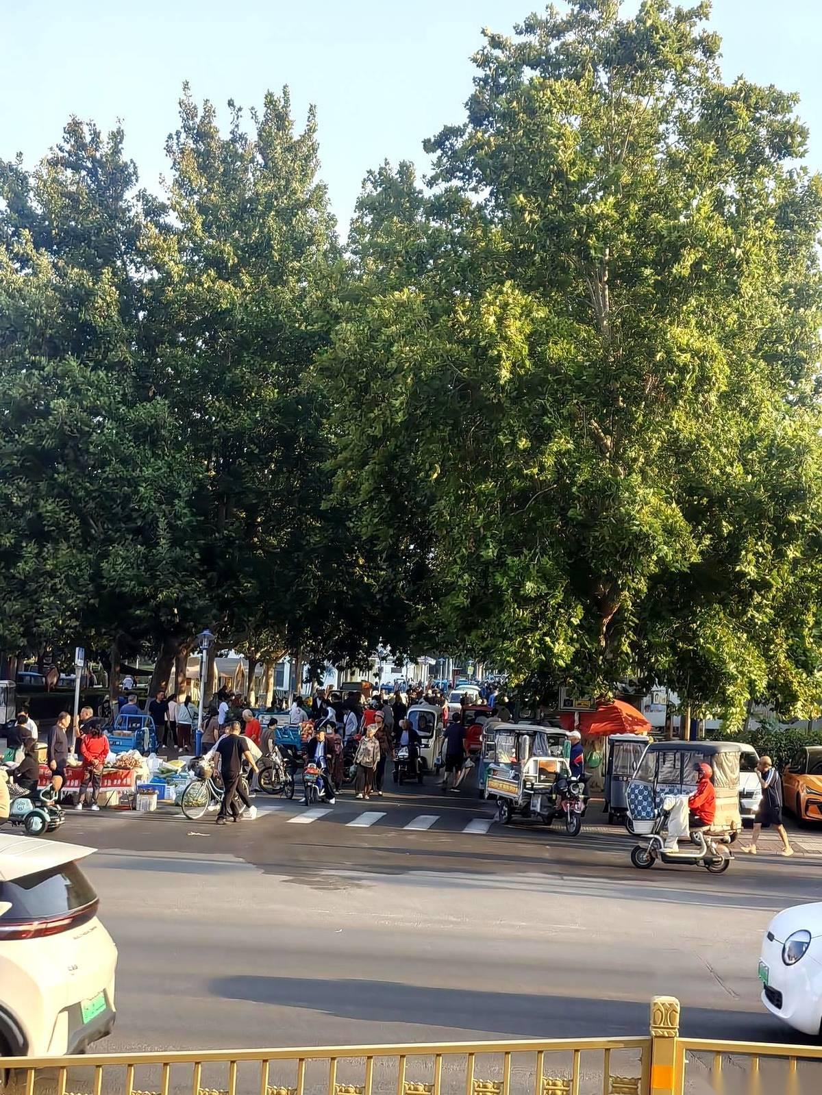 济宁新世纪广场那个未经审批自筹自建的早市儿，如今的摊位已经把整个广场公园死死环绕