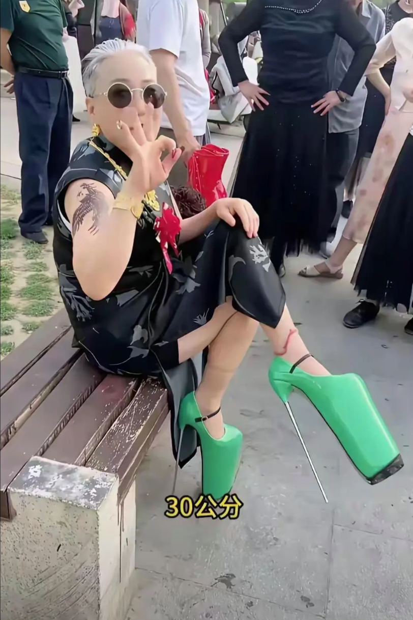 马路边，一名女子打扮十分奇特！穿着黑色旗袍，坐在路边的椅子上，不料，仔细看她的鞋