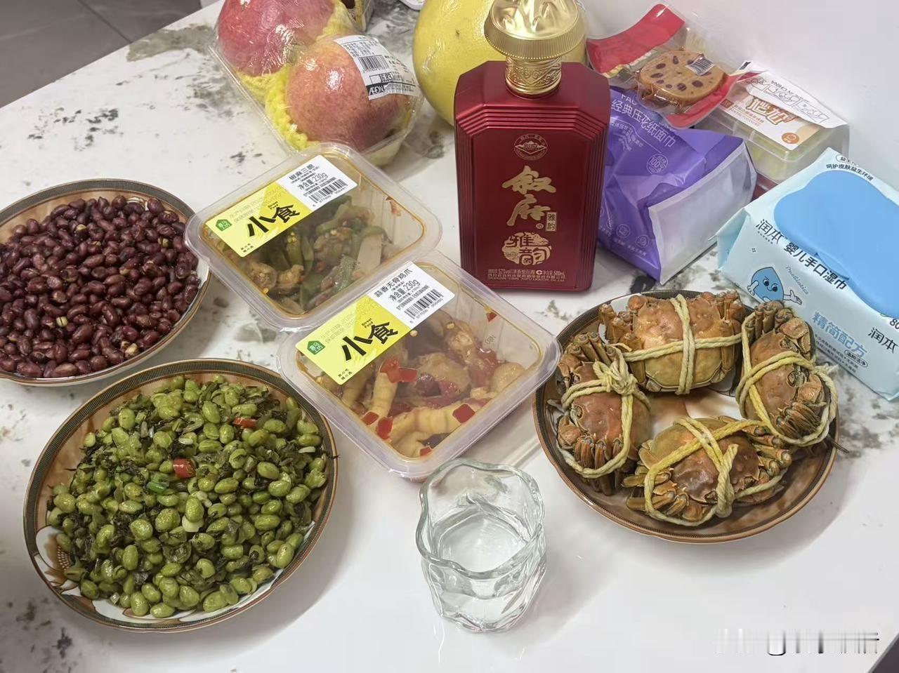 一桌简单的家常菜，卤花生、清炒毛豆，爽口小菜配上酸辣凤爪，再摆上几只饱满肥硕的螃