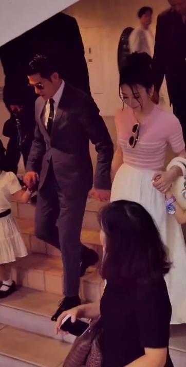 今天郭富城和方媛带着两个女儿一起出席活动，一家四口手牵手并排行走，看起来真的是很