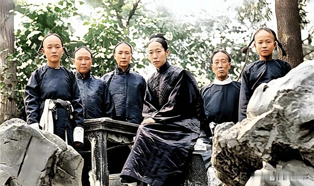 隆裕太后与太监假山留影。镜头下，隆裕太后一身深色宫廷服饰，面容平淡，神色郁郁。周