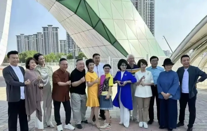 这是近期央视十多位老主持人团建时的合影，其他的主持人都显得庄重，但站在c位的刘纯