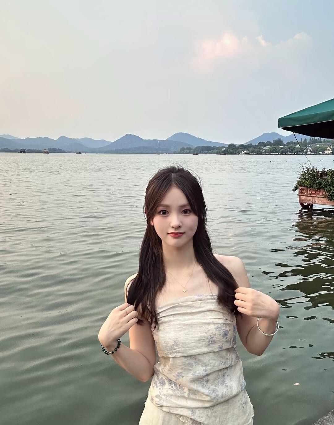 在湖边轻抚发丝，感受自然的宁静与美好。