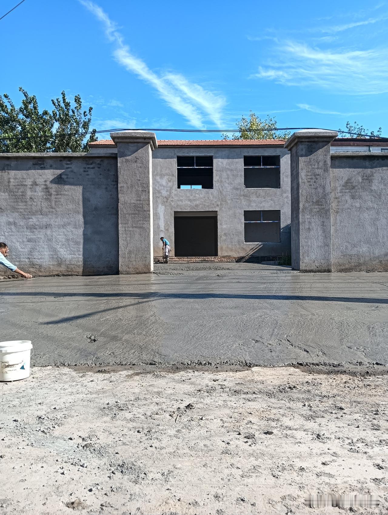 工人在新房子前铺水泥地面。水泥地施工现场