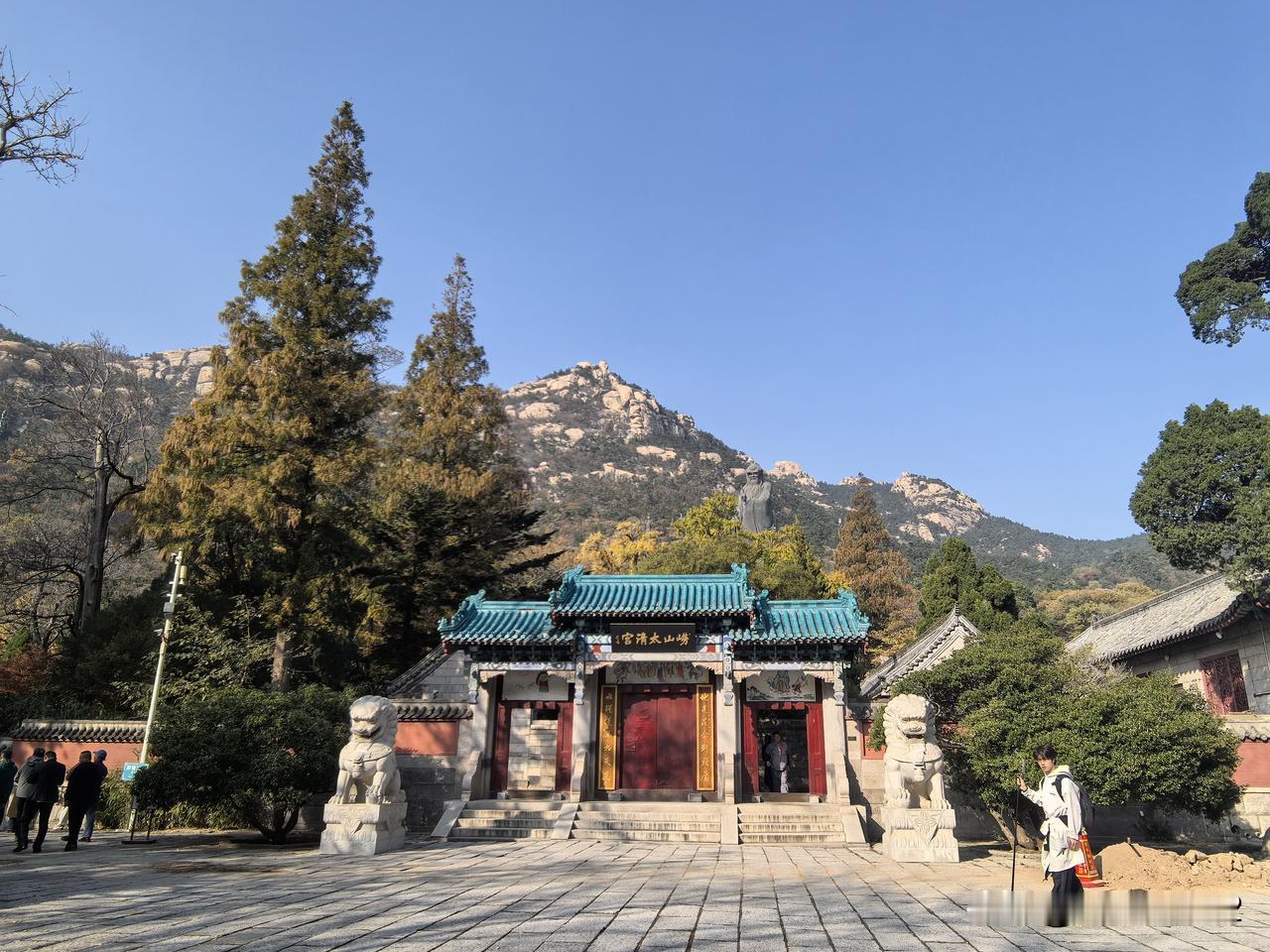 孔子的巨幅雕像矗立在郁郁葱葱的高大的松柏之中，仔细看才能看出来。建议游览青岛崂