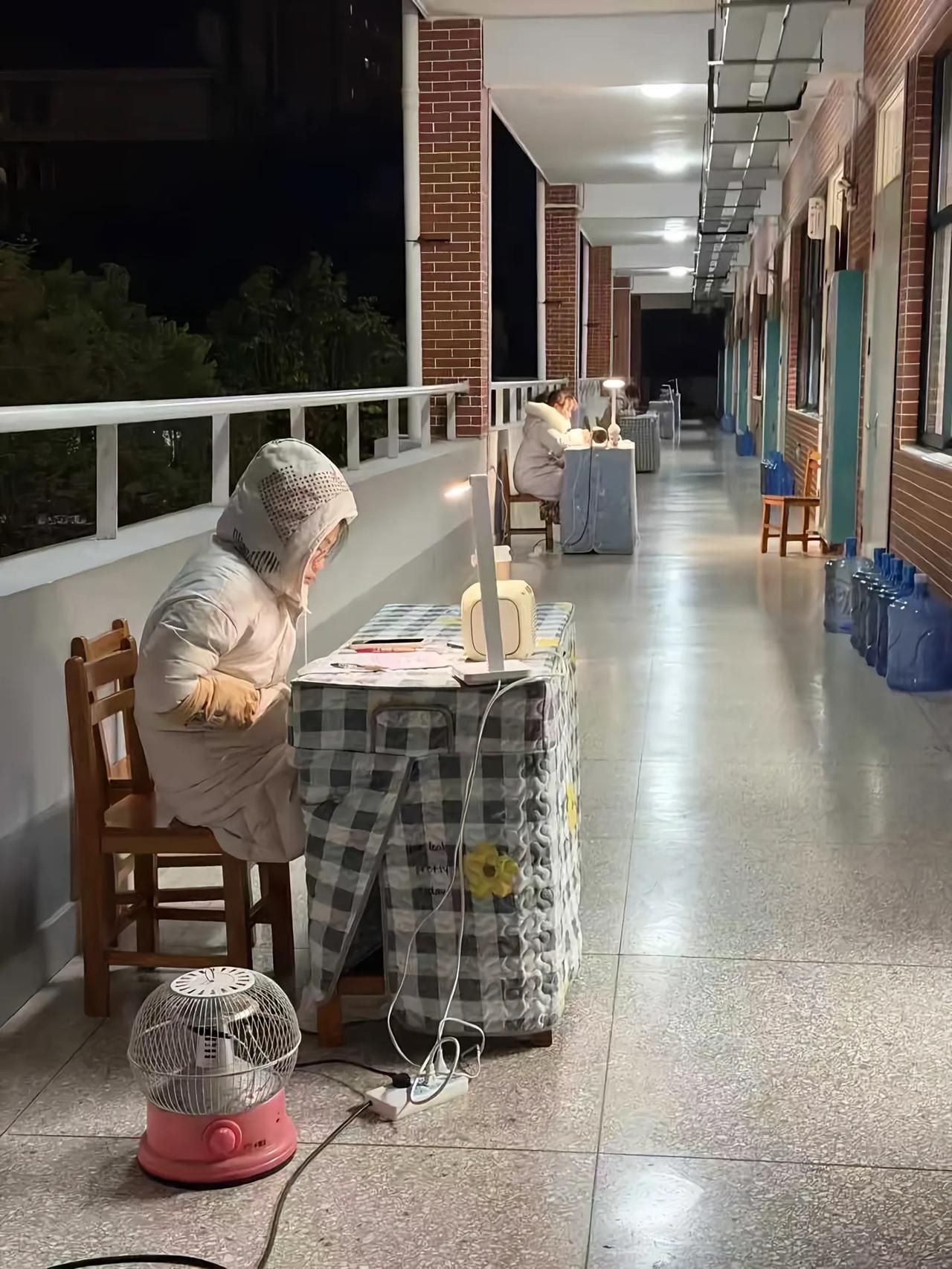 网友反映老师在走廊办公，寒冬腊月四九天老师坐在教学楼的走廊里批改作业和解决学生问