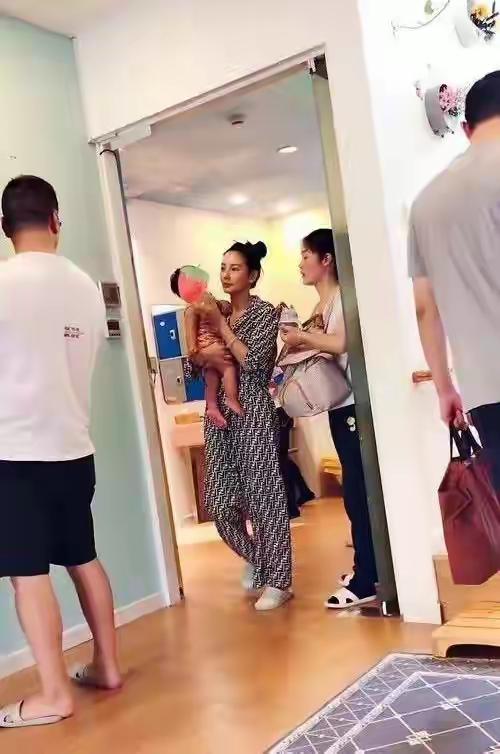 张雨绮抱娃，图一抱的是自己的娃，图二抱的是别人的娃。当了妈妈的女人就是不一样，身