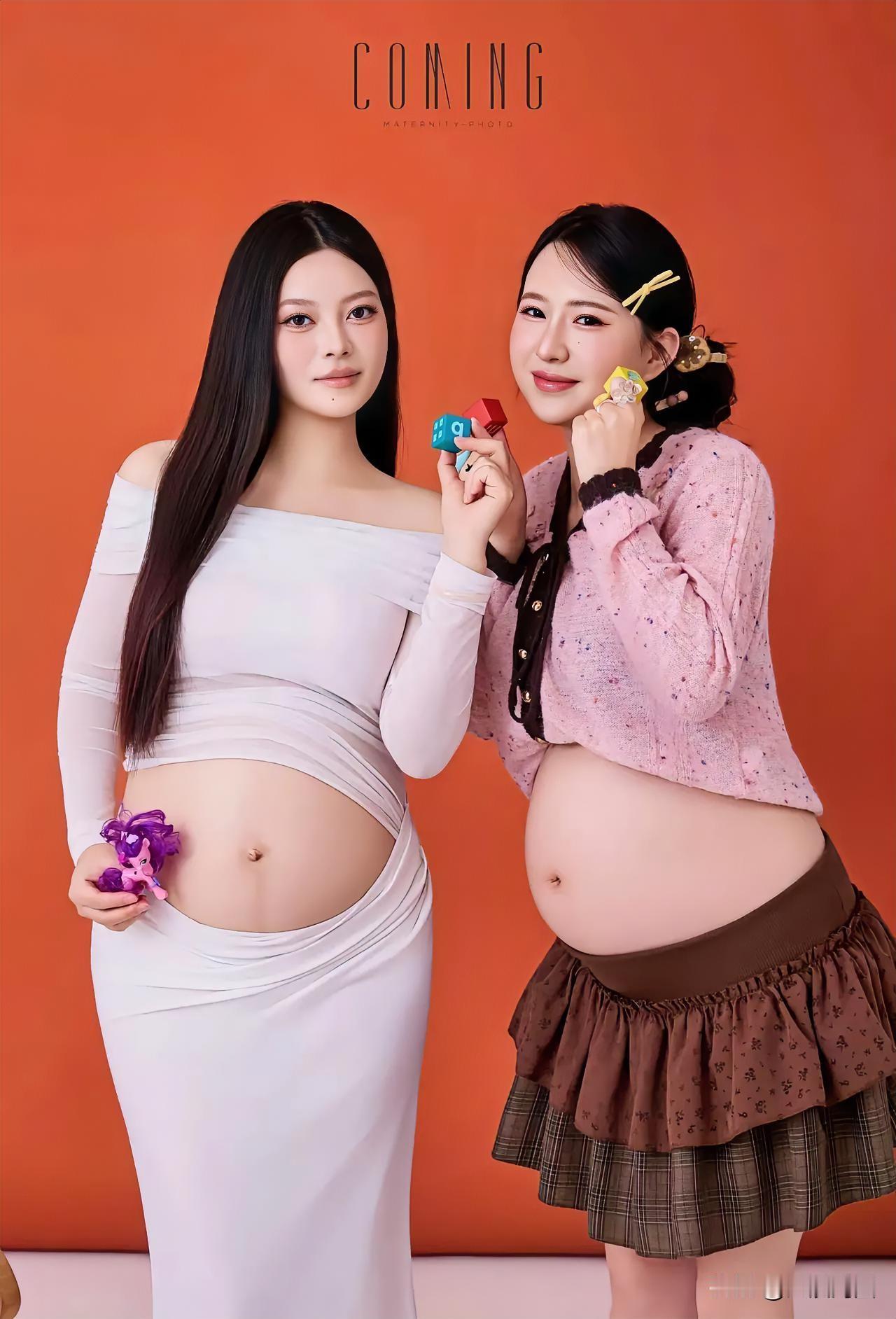 两位孕妇摆好姿势拍照，背景是橙色。温柔风孕妈照孕妈出游照红色孕照孕期体式照