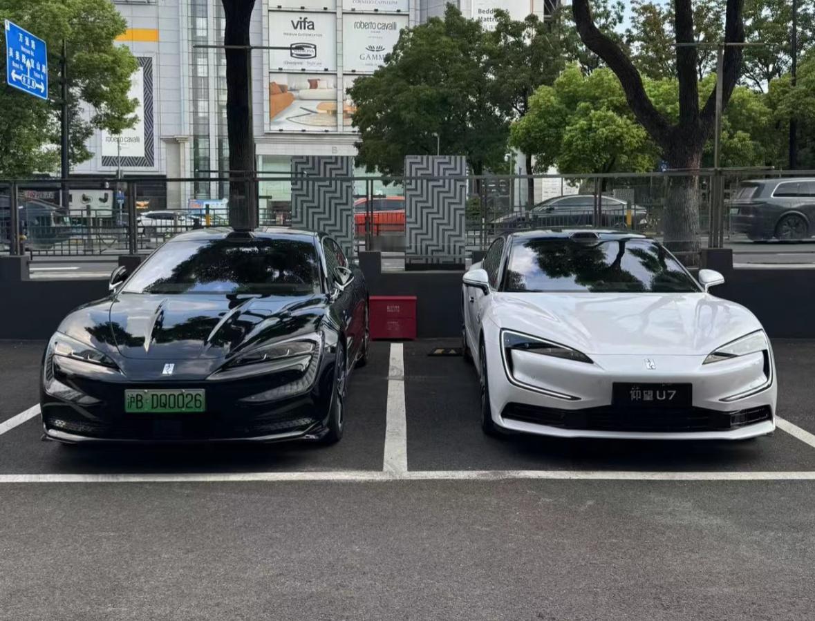 图一左边是纯电仰望U7，后边是插混仰望U7，插混版车灯更细、引擎盖少了两道筋线，