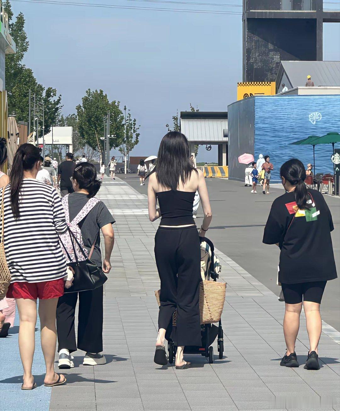 37岁超模何穗带着1岁儿子现身河北旅游，她穿着一身黑色，整个人又高又瘦，皮肤白到