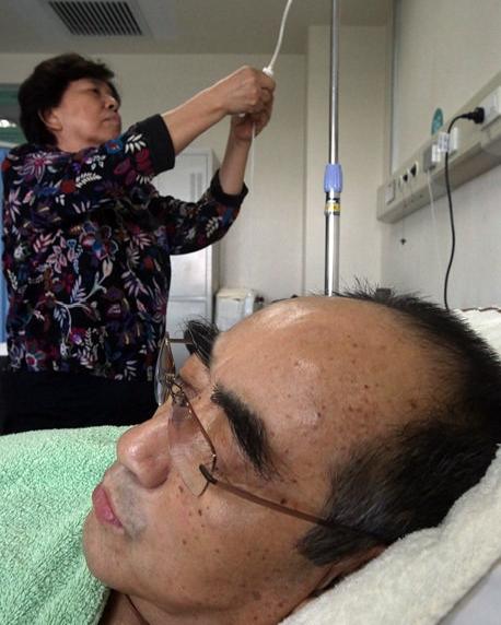 2012年，乒乓球名将庄则栋，躺在病床上打点滴，妻子佐佐木墩子就安安静静守在旁边