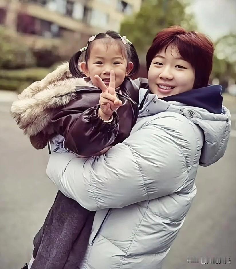 蒯曼抱着的是她的妹妹。姐妹俩相差十四岁。妹妹傲娇的伸出两根手指，她们俩是两个世