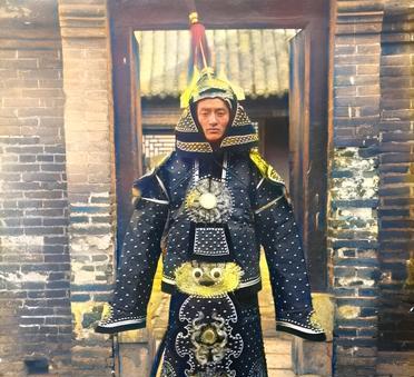 这是清朝一名男子身穿祖上留下的霸气甲胄。这名男子应该是名旗人。他身后的这座房子应